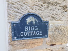 A nameplate for Rigg Cottage on a stone wall