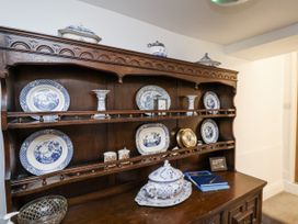 A wooden cabinet with decorative plates and bowls at Rigg Cottage in Sandsend