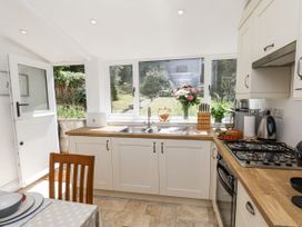 A kitchen with sink, stove, and windows at Rigg Cottage in Sandsend