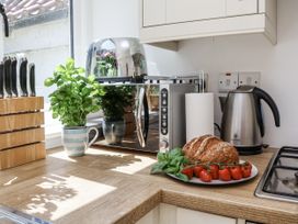 A kitchen with a toaster, kettle, and food items at Rigg Cottage in Sandsend