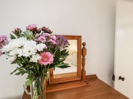 A bouquet of flowers and a mirror on a table at Rigg Cottage in Sandsend
