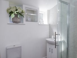 A bathroom featuring a shower, sink, toilet, and window at Rigg Cottage in Sandsend