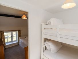 A bedroom with a bunk bed and a single bed at Rigg Cottage in Sandsend