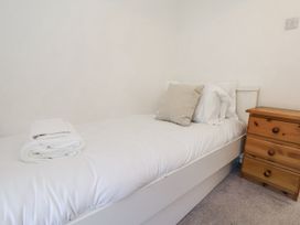 A bed with pillows and towels in a bedroom at Rigg Cottage in Sandsend