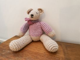 A crochet bear sitting on a wooden surface at Rigg Cottage in Sandsend