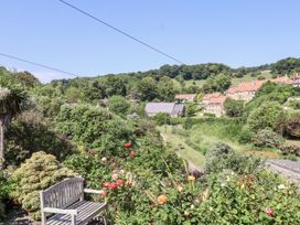 An outdoor view with flowers and a bench at Rigg Cottage in Sandsend