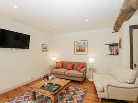 A living room with a television and sofa at Stable cottage Sopworth near Sherston