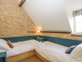 A bedroom with two beds and a lamp at Stable cottage Sopworth near Sherston