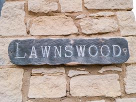 A sign that reads Lawnwood against a stone wall