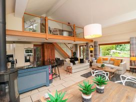 A living room with a staircase and kitchen appliances at Lawnswood