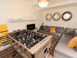 A snug with a foosball table and a sofa at Lawnswood