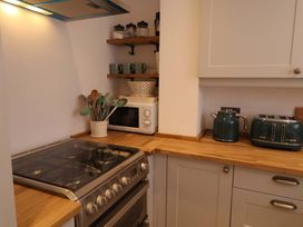A kitchen with stove, microwave, kettle, and toaster at 11 Ballygate in Babbacombe