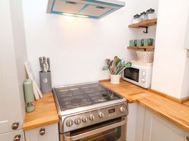 A kitchen with stove and microwave at 11 Ballygate in Babbacombe