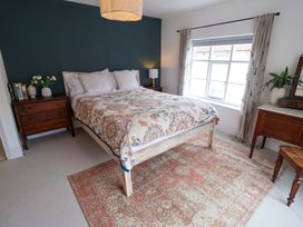 A bedroom with a bed, side tables, and a window at 11 Ballygate in Babbacombe