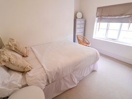 A bedroom with a bed, cushions, drawer unit, and a chair at 11 Ballygate in Babbacombe