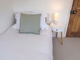 A bedroom with a bed, cushion and lamp at 11 Ballygate Babbacombe