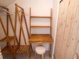 A closet with a clothes rack, shelf, desk, and stool at 11 Ballygate in Babbacombe