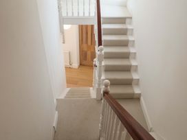 A staircase with a handrail and door at 11 Ballygate in Babbacombe