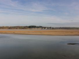 A coastal landscape with water and sandbanks and houses in the distance at 101 Atlantic Bays Holiday Park in Padstow
