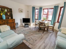 A living room with a dining area and television at Flat 9 in Swanage