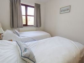 A bedroom with two beds and a window at Flat 9 in Swanage