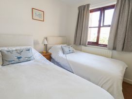 A bedroom with two beds and a window at Flat 9 in Swanage