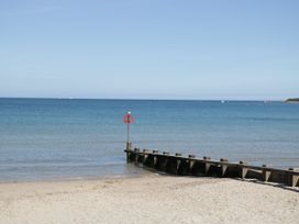 A beach with a pier and lifebuoy at Flat 9 in Swanage
