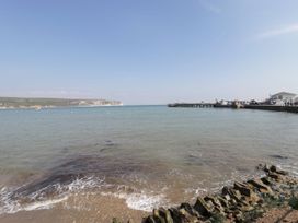 A view of the sea and pier with cliffs in the background at Flat 9 in Swanage