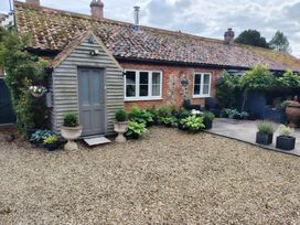 A garden with plants and a wooden garden shed at Cosy Cottage in North Elmham