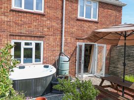 A garden with a hot tub and patio table at 3 Birkbeck Way Norwich