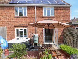 A garden with a hot tub and patio umbrella at 3 Birkbeck Way Norwich