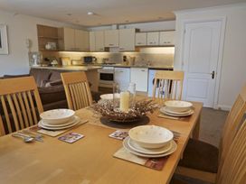 A dining table set with plates and bowls in an open kitchen and living area at 10 Dartmouth House in Dartmouth