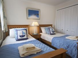 A bedroom with two single beds blue bed covers and boat themed pillows at 10 Dartmouth House in Dartmouth