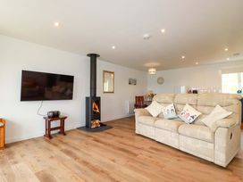A living room with a fireplace and television at Folly View in Cambrose near Illogan
