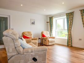 A living room with armchairs and a table at Folly View Cambrose near Illogan