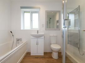A bathroom with a bathtub, toilet, sink, and shower at Folly View in Cambrose near Illogan