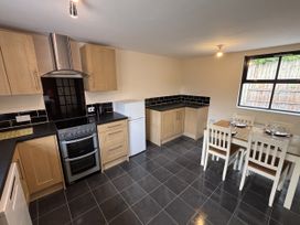 A kitchen with cabinets, oven and dining table at The Studio in Marsham near Aylsham