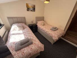 A bedroom with two single beds and a nightstand at The Studio in Marsham near Aylsham