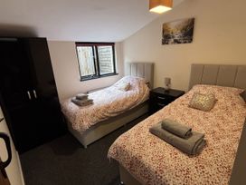 A bedroom with two beds and a wardrobe at The Studio in Marsham near Aylsham