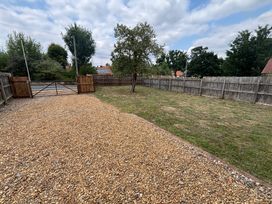 A garden area with a gravel driveway and a tree at The Studio in Marsham near Aylsham