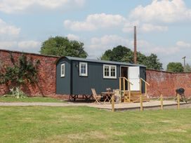 A shepherd's hut with outdoor seating area at Shepherd's Hut in Wrexham