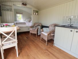 A living area with a bed and dining table at Shepherd's Hut in Wrexham