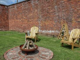 A garden with a fire pit and chairs at Shepherd's Hut in Wrexham