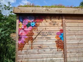 A wooden wall with a floral mural and a quote at Shepherd's Hut in Wrexham