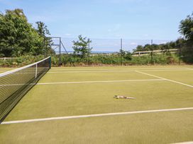 A tennis court with net and racket in Wrexham