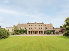 A house with a lawn and trees at The Garden Hut in Wrexham