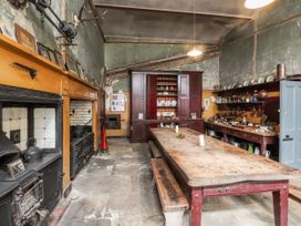 A kitchen with stove and wooden table at The Garden Hut in Wrexham