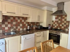 A kitchen with modern appliances and wooden furniture at Acorn Lodge Finlakes Holiday Park near Chudleigh