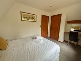 A bedroom with a double bed and desk at Acorn Lodge Finlakes Holiday Park near Chudleigh