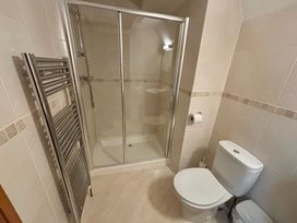 A bathroom with a shower, toilet and towel radiator at Acorn Lodge Finlakes Holiday Park near Chudleigh